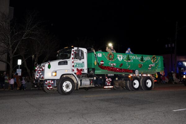 The Spartan Waste Christmas parade truck decorated with holiday lights in downtown Spartanburg.