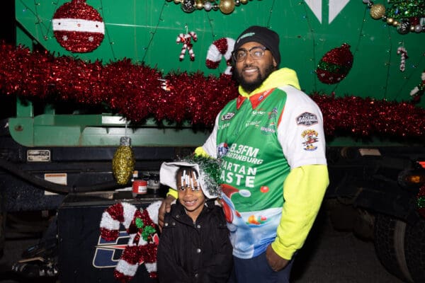 Spartan Waste team member smiling with a child at the Spartanburg Christmas Parade